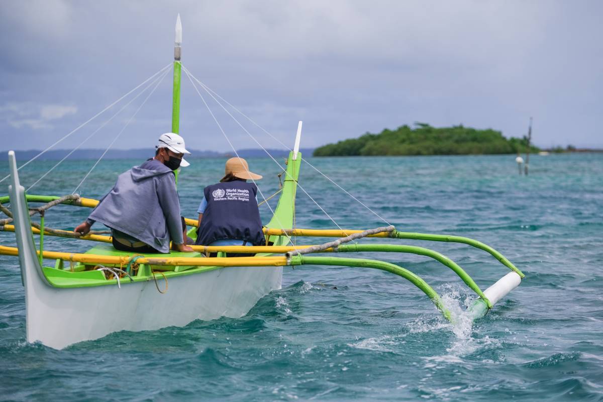 Health workers on a green and yellow boat headed to Manicani island, Philippines